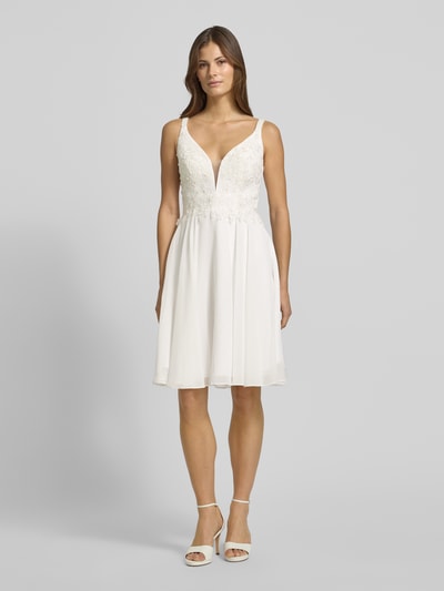 Frauenmodel trägt Cocktailkleid mit Herz-Ausschnitt von LUXUAR FASHION in Weiß, taillierter Schnitt, Strasssteinen, Häkelspitze, Minilänge, Ganzkörperansicht von vorne.