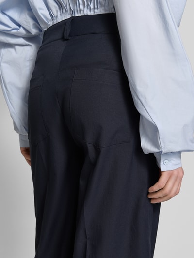 Frauenmodel trägt Stoffhose mit Eingrifftaschen Modell 'CARA' von Cambio, dunkelblau, Wide-Fit, Haken- und Reißverschluss, Detailaufnahme Rückansicht.