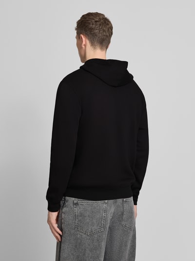 Mannenmodel draagt 'Sweatjacke mit getrennter Kängurutasche' van GAP in zwart, katoenmix, loose fit, rugaanzicht, context inbegrepen.