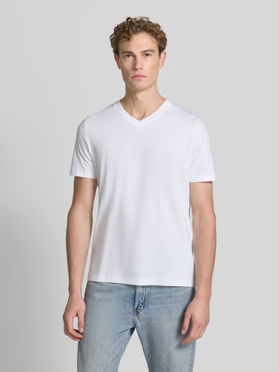 Männermodel trägt Regular Fit T-Shirt aus reiner Baumwolle von s.Oliver RED LABEL in Weiß, glatte Textur, Ganzkörperansicht von vorne.