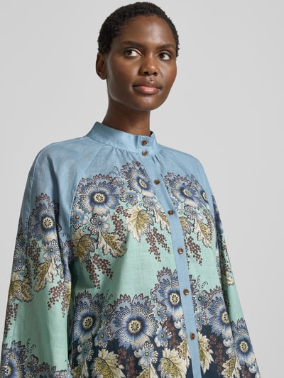 Vrouwenmodel draagt Relaxed Fit Bluse aus reiner Baumwolle von Rich & Royal, bloemen all-over print in blauw en groen, opstaande kraag, met lange mouwen, knoopsluiting, puur katoen, maat 36 ruglengte 59 cm, mouwlengte 66 cm, Nahaufnahme bovenlichaam.