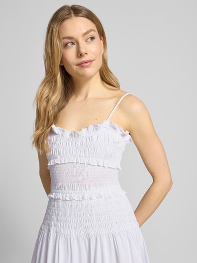 Frauenmodel trägt Midikleid mit Rüschen und Volantsaum von MICHAEL Michael Kors, reine Baumwolle, tailliert, Spaghettiträger, Karree-Ausschnitt, Smok-Details, weiß, Nahaufnahme Oberkörper.