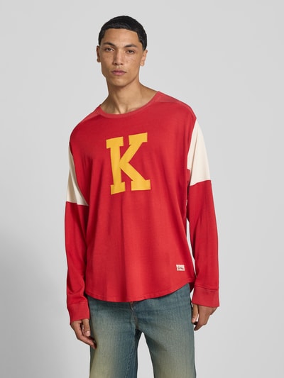 Männermodel trägt Relaxed Fit Longsleeve aus viscosemix van Kenzo, rode en crème kleurvlakken, ronde hals, labelstitching, elastische mouwen, ruglengte maat M 73 cm, heren, voorkant, Ganzkörperansicht von vorne