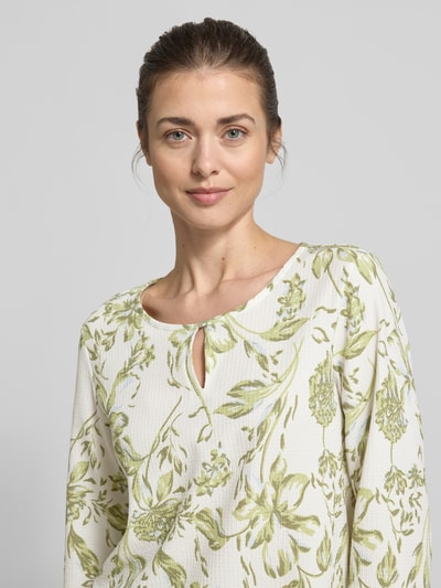Frauenmodel trägt Regular Fit T-Shirt mit Allover-Muster von s.Oliver RED LABEL in Weiß-Grün, Rundhals mit Schlüsselloch-Ausschnitt, 3/4-Arm, Materialverarbeitung: Crinkle, Nahaufnahme Oberkörper.