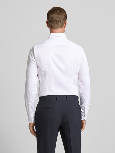 Männermodel trägt Slim Fit Businesshemd aus Baumwoll-Mix Modell 'HANK' von BOSS, Optik: unifarben, Struktur, Ganzkörperansicht Rückansicht.