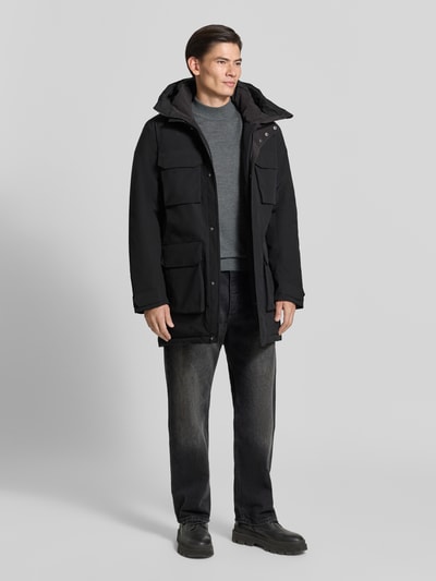 Männermodel trägt Parka mit Kapuze und Pattentaschen Modell 'AIDEN' von Didriksons, Regular Fit, verdeckter Reißverschluss, Ganzkörperansicht von vorne.
