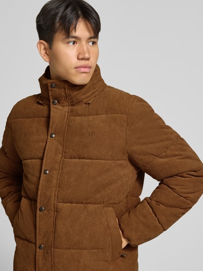 Männermodel trägt Steppjacke in Cord-Optik von Superdry in Braun, sichtbare Knopfleiste und Kapuze, gerade Passform, Nahaufnahme Oberkörper