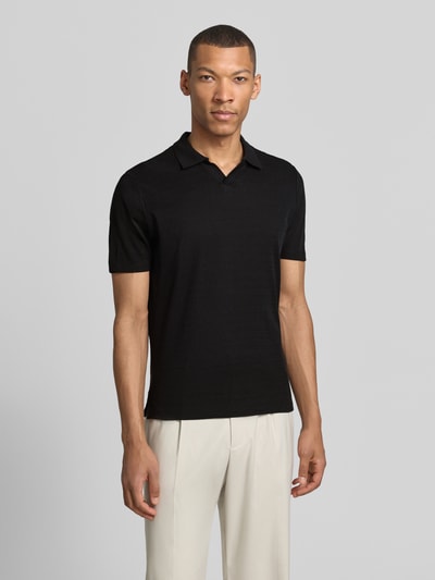 Männermodel trägt Modern Fit Poloshirt mit Polokragen und Label-Detail von MARKUP aus reiner Baumwolle, schwarze Farbe, Ganzkörperansicht von vorne. Rückenlänge bei Größe M: 70 cm.
