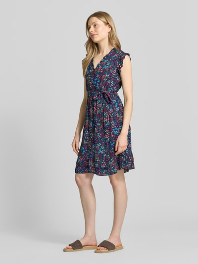 Frauenmodel trägt Minikleid aus reiner Viskose mit floralem Allover-Print von Apricot, taillierte Passform, Ganzkörperansicht von vorne.