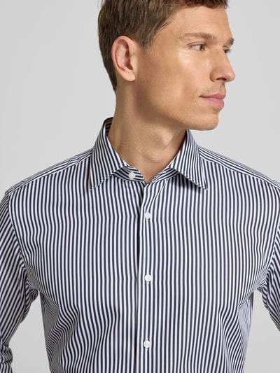 Männermodel trägt Regular Fit Businesshemd aus reiner Baumwolle Modell 'JOE' von BOSS, Optik: Allover-Muster, gestreift, Nahaufnahme Oberkörper.