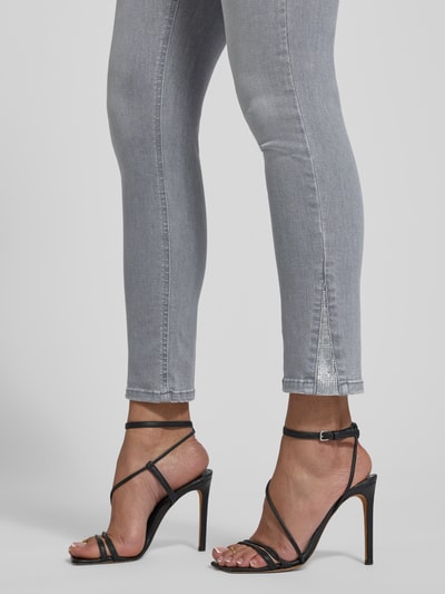 Frauenmodel trägt Skinny Fit Jeans im Used-Look mit Eingrifftaschen Modell 'IDEAL' von Liu Jo White in Grau, Baumwoll-Mix mit Stretch-Anteil, Detailaufnahme Beinpartie.