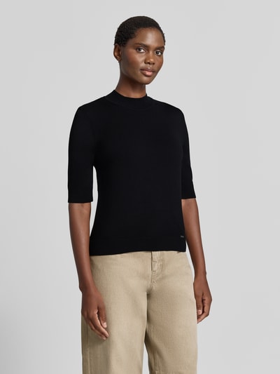 Vrouwenmodel draagt gebreid shirt uit viscosemix met stretch, recht model, geribde ronde hals, 1/2-mouwen, labeldetail van MORE, ruglengte maat 36: 55 cm, mouwlengte maat 36: 29 cm, Ganzkörperansicht van voren.