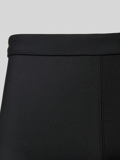 Produktfoto, schwarze Slim Fit Bade-Trunks mit Logo-Detail von Calvin Klein Underwear, elastischer Material-Mix, feine Textur