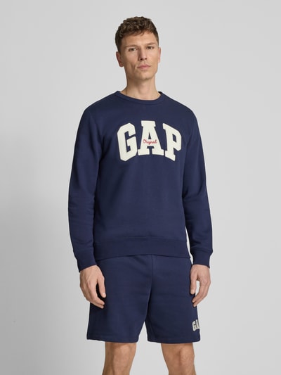 Männermodel trägt Sweatshirt mit Logo und Rundhalsausschnitt von GAP, dunkelblauer Baumwoll-Mix, Regular-Fit, Logo, Ganzkörperansicht von vorne.