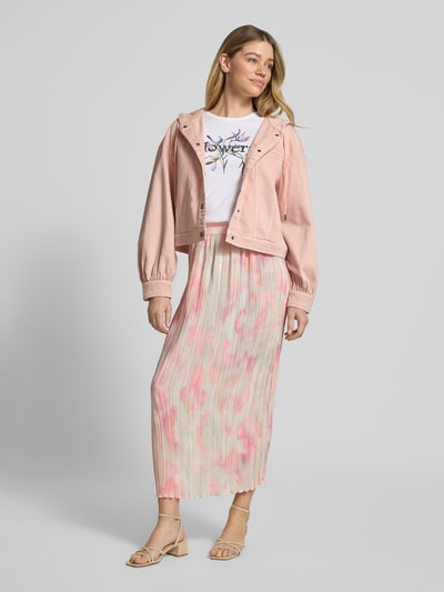 Frauenmodel trägt Ausgestellter Midi-Rock mit Plissees von Marc Cain mit Allover-Muster in Rosa und Grün, Regular Fit, elastischer Bund, Ganzkörperansicht von vorne.