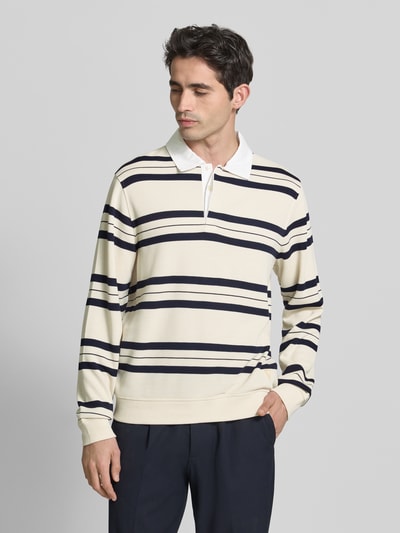 Męski model nosi Regular Fit Poloshirt mit Streifenmuster von GUESS, mieszanka materiałów z dodatkiem wiskozy, kołnierzyk polo, bluzka z długim rękawem, wzór w paski, długość tyłu w rozmiarze M 71 cm, długość rękawów 72 cm, widok na całe ciało z przodu.