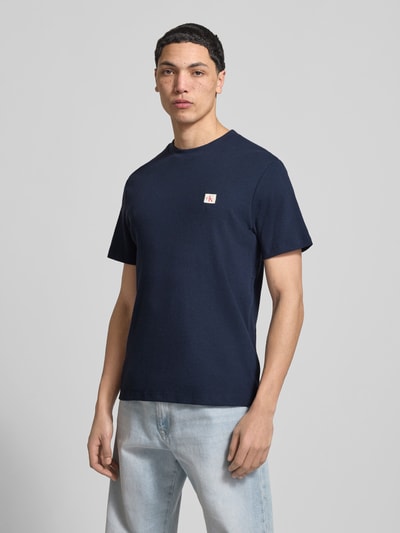 Männermodel trägt Regular Fit T-Shirt mit Logo-Patch von Calvin Klein Jeans aus Baumwoll-Mix mit Strukturmuster, Rundhalsausschnitt, Ganzkörperansicht von vorne.