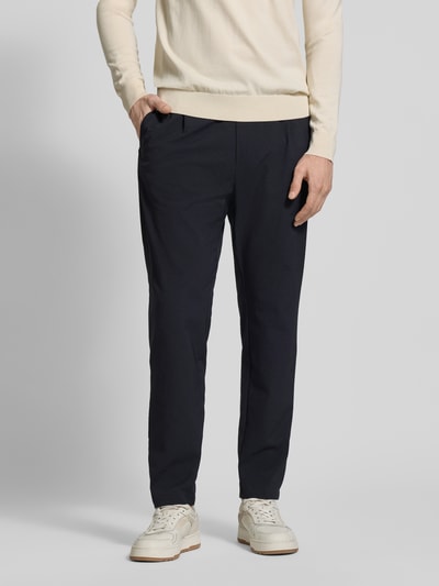 Męski model nosi Slim Fit Stoffhose mit Strukturmuster od CRUNA, elastyczna mieszanka materiałów, krój slim fit, fakturowany wzór, kieszenie z tyłu, elastyczny pas, wpuszczane kieszenie, szerokość w rozmiarze 50: 44 cm, długość wewnętrzna nogawki w rozmiarze 50: 79 cm, widok na całe ciało z przodu.