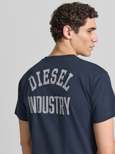 Männermodel trägt Regular Fit T-Shirt aus reiner Baumwolle von Diesel in Dunkelblau mit Label-Applikation, Kurzärmelig, Rückenlänge 70 cm, Nahaufnahme Rückansicht.