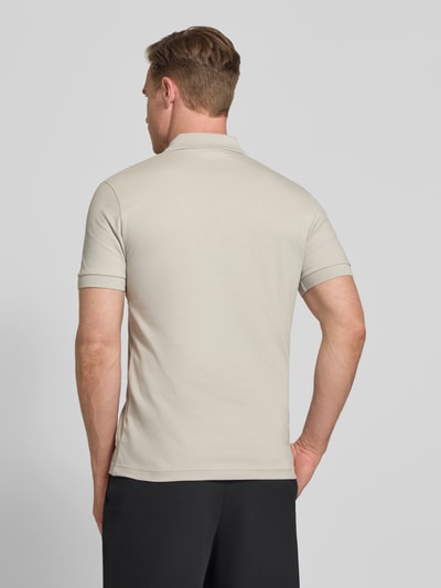 Männermodel trägt Slim Fit Poloshirt aus Baumwoll-Mix Modell 'PASSERZIP' von BOSS Orange, Optik: Unifarben, Ganzkörperansicht Rückansicht.