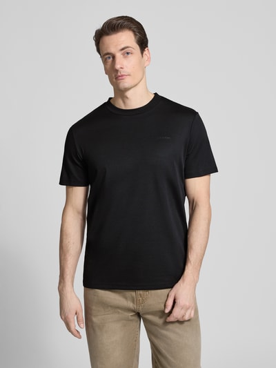 Mannenmodel draagt T-Shirt met Rundhalsausschnitt van CK Calvin Klein, katoenmix, regular fit, zwarte kleur, voorkant volledig zichtbaar, bovenlichaam close-up. Ruglengte maat M: 69 cm.