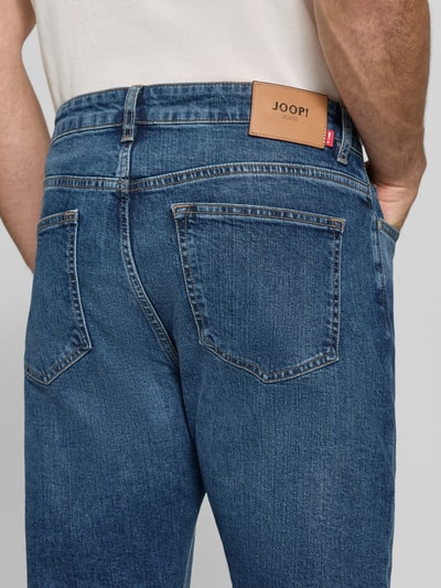 Männermodel trägt Straight Fit Jeans aus Baumwoll-Mix Modell 'Ray' von JOOP! JEANS, blaue Denim-Struktur, Detailaufnahme Rückansicht.