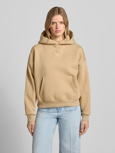 Frauenmodel trägt Hoodie mit Motiv-Stitching und Känguru-Tasche von REVIEW aus Baumwoll-Mix, Regular-Fit, Beige, Ganzkörperansicht von vorne.