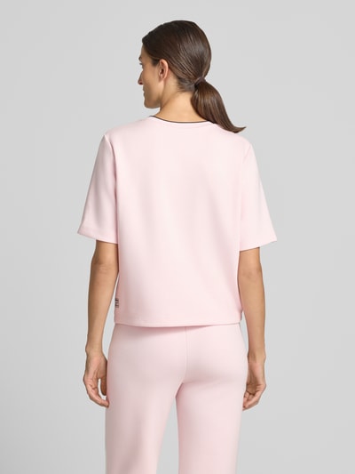 Vrouwenmodel draagt Relaxed Fit T-shirt uit viscosemix van Marc Cain in lichtroze met logodetail en ronde hals, ruglengte maat 36: 54 cm, Ganzkörperansicht Rückansicht.