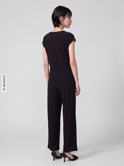 Vrouwenmodel draagt Regular fit jumpsuit met zij-steekzakken model 's.NOS' van ROBE LÉGÈRE in zwart, volledig van achteren, KI-modificeerd beeld