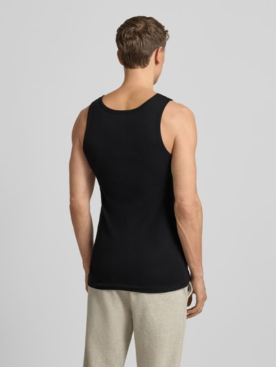 Männermodel trägt Tanktop aus reiner Baumwolle im 2er-Pack von TOM TAILOR, schwarze feine Rippenstruktur, schmaler Schnitt, Ganzkörperansicht Rückansicht.