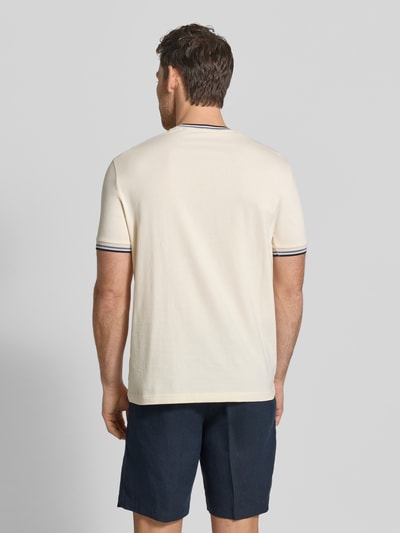 Męski model nosi T-Shirt mit Kontraststreifen und Rundhalsausschnitt von Christian Berg Men, bawełna z domieszką elastanu, krój regular fit, kontrastowe paski, okrągły dekolt, długość tyłu w rozmiarze M: 71 cm, jasny materiał z ciemniejszymi akcentami, gładka faktura, pełny tył, widok całej sylwetki z tyłu.