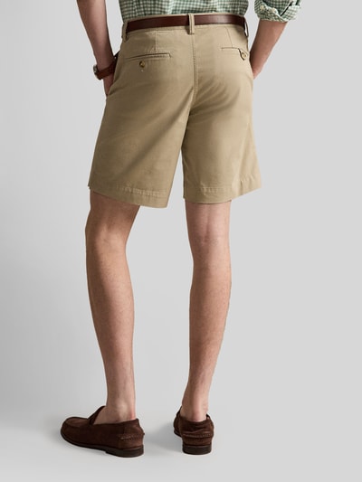 Männermodel trägt Straight Fit Chinoshorts aus Baumwoll-Mix von Polo Ralph Lauren, efekt: jednolity kolor, krój straight fit, detal z logo, szlufki na pasek, zapięcie na guzik i zamek błyskawiczny, kieszeń z tyłu, wpuszczane kieszenie, mieszanka bawełny, kolor beżowy, gładka struktura, Ganzkörperansicht Rückansicht.