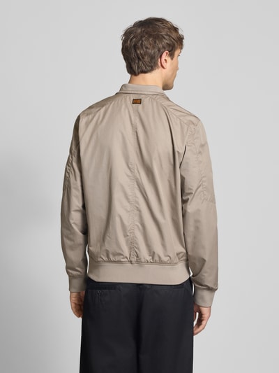 Männermodel trägt Jacke mit Stehkragen und Reißverschluss von G-Star Raw in Beige, Regular Fit, Baumwoll-Mix, Ganzkörperansicht Rückansicht.