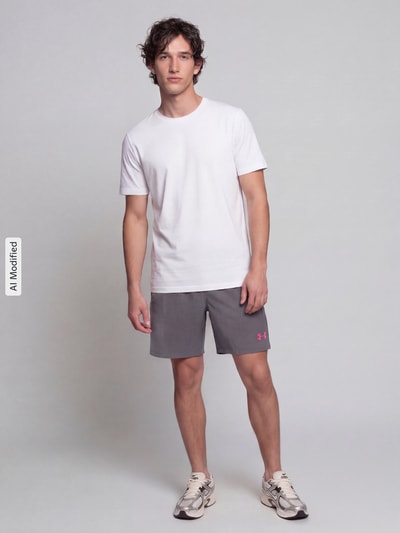 Männermodel trägt graue Regular Fit Sportshorts mit logoprint van Under Armour, Heren Sportshorts, ganzkörperansicht von vorne, KI-modifiziertes Bild