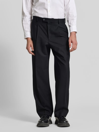 Männermodel trägt Straight Fit Stoffhose mit Bundfalten von ANNARR in Schwarz mit Eingrifftaschen, Ganzkörperansicht von vorne.
