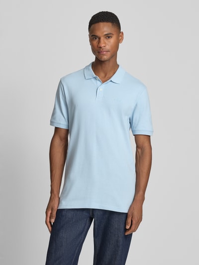 Männermodel trägt Slim Fit Poloshirt mit Label-Stitching von GAP in Hellblau, Baumwoll-Elasthan-Mix, Ganzkörperansicht von vorne.