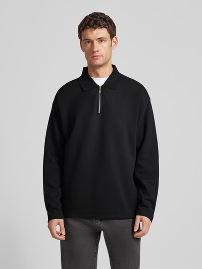 Męski model ma na sobie Sweatshirt mit Polokragen und Reißverschluss od CK Calvin Klein, czarny, model CRINKLE CREPE SPACER, strukturalny wzór, mieszanka materiałów z modalem, relaxed fit, widok całej sylwetki z przodu.
