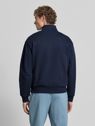 Männermodel trägt Regular Fit Troyer aus Baumwoll-Mix von Lacoste in Dunkelblau, glatte Textur, Ganzkörperansicht Rückansicht. Herren Troyer von Lacoste