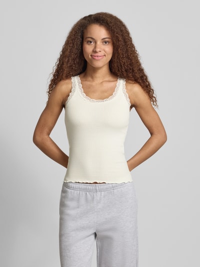Vrouwenmodel draagt slim fit tank top uit bio-katoenmix model 'SARA' van Only, effen kleuren, fijnrib, u-hals, detail van kant, model met bandjes, vooraanzicht, close-up bovenlichaam.