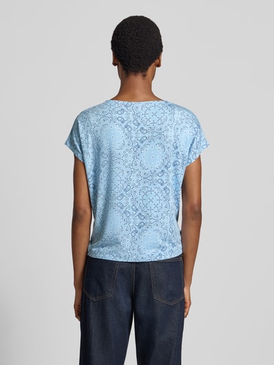Frauenmodel trägt Relaxed Fit T-Shirt aus Viskose-Mix von s.Oliver RED LABEL in Hellblau mit Paisley-Muster, Ganzkörperansicht Rückansicht.