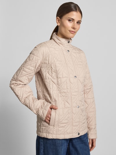 Frauenmodel trägt Steppjacke mit Stehkragen und Eingrifftaschen von Fuchs Schmitt in Beige, Regular Fit, Knopfleiste, Ganzkörperansicht von vorne, Rückenlänge bei Größe 36: 64 cm, Schulterbreite 43 cm, Brustweite 49 cm, Ärmellänge 65 cm.