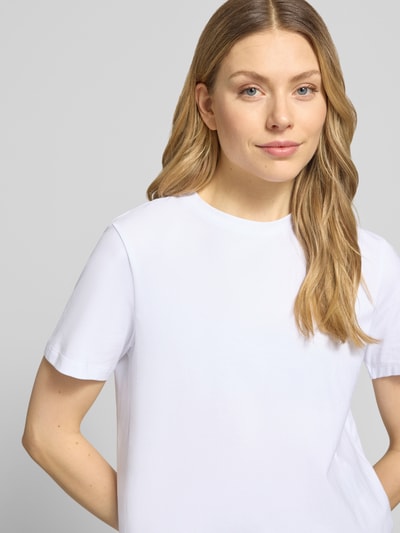 Frauenmodel trägt T-Shirt mit geripptem Rundhalsausschnitt Modell 'NORA' von Vila aus Baumwoll-Elasthan-Mix, lockerer Schnitt, Nahaufnahme Oberkörper.