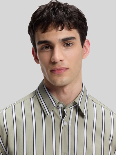 Männermodel trägt Regular Fit Freizeithemd aus reiner Baumwolle Modell 'Ebalto_1' von HUGO, grün mit schwarzen Streifen, Nahaufnahme Oberkörper. Herren Freizeithemd von HUGO Blue.