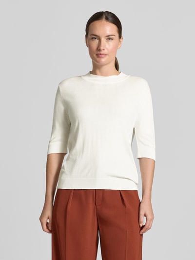 Frauenmodel trägt Strickpullover aus Viskose-Mix von MORE & MORE in Weiß mit Halbarm und Stehkragen, taillierte Passform, Ganzkörperansicht von vorne.