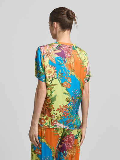 Frauenmodel trägt Relaxed Fit T-Shirt aus reiner Viskose von Liu Jo White, Floraler-Print, Allover-Print, bunte Farben, Rückenlänge 61 cm, Ganzkörperansicht Rückansicht.