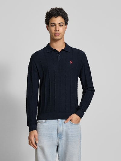 Männermodel trägt Strickpullover mit Strukturmuster und Polokragen von REVIEW, Reine Baumwolle, Slim-Fit, Logo-Bestickung, Ganzkörperansicht von vorne.