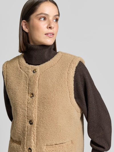 Vrouwenmodel draagt bodywarmer van Teddybont Model 'Eddy' van FREE/QUENT, regular fit, paspelzakken, ruglengte maat S 58 cm, schouderbreedte S 38 cm, borstwijdte S 51 cm, detailopname bovenlichaam.