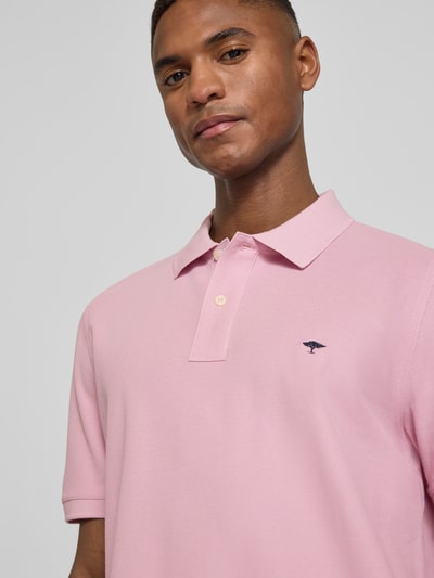 Männermodel trägt Regular Fit Poloshirt mit Logo-Stitching von Fynch-Hatton in Rosa, reine Baumwolle, Nahaufnahme Oberkörper