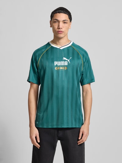 Männermodel draagt Regular Fit Jersey mit Logo-Print van PUMA PERFORMANCE in donkergroen met logoprint, puur katoen, V-hals, ganzkörperansicht van voren.