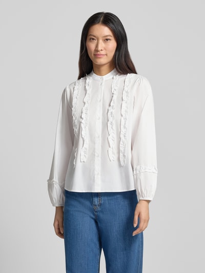 Frauenmodel trägt Regular Fit Bluse aus Baumwoll-Mix mit Rüschenbesatz von MORE & MORE in Weiß, Stehkragen, Jeans, Ganzkörperansicht von vorne. Rückenlänge 65 cm, Ärmellänge 60 cm, elastischer Baumwoll-Mix, langärmelig, durchgehende Knopfleiste.